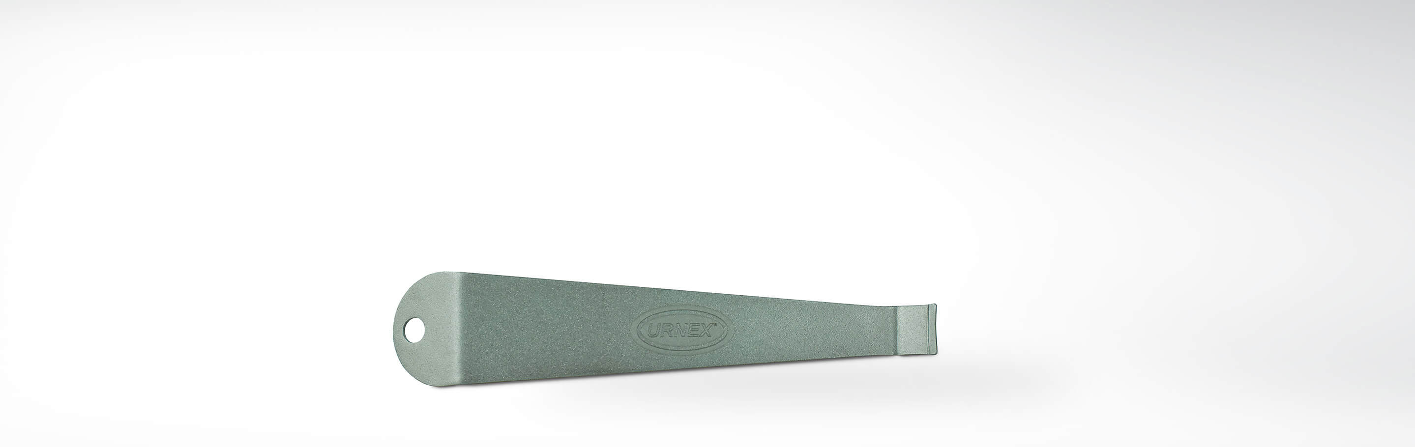 Grünes Urnex Reinigungswerkzeug für Espressomaschinen vor weißem Hintergrund