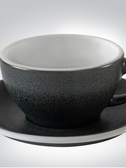 Schwarze Keramiktasse mit passender Untertasse auf neutralem Hintergrund