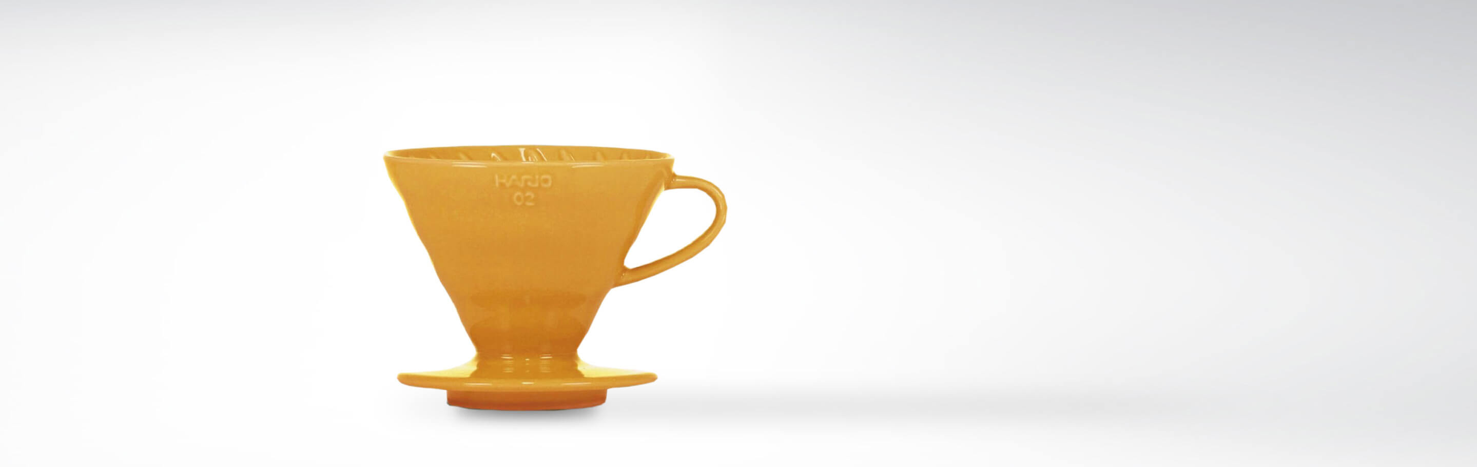 Gelber Keramik-Kaffeefilter von Hario auf weißem Hintergrund