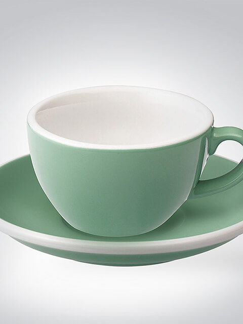 Grüne Teetasse mit passender Untertasse auf einem hellen Hintergrund