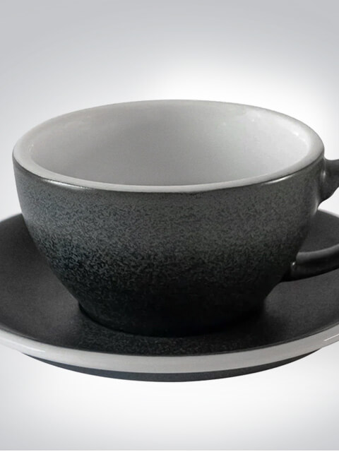 Stilvolle schwarze Kaffeetasse mit Untertasse Eine elegante schwarze Kaffeetasse mit passender Untertasse auf grauem Hintergrund