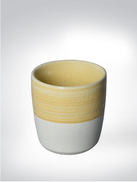 Keramikbecher mit gelben und weißen Streifen auf weißem Hintergrund