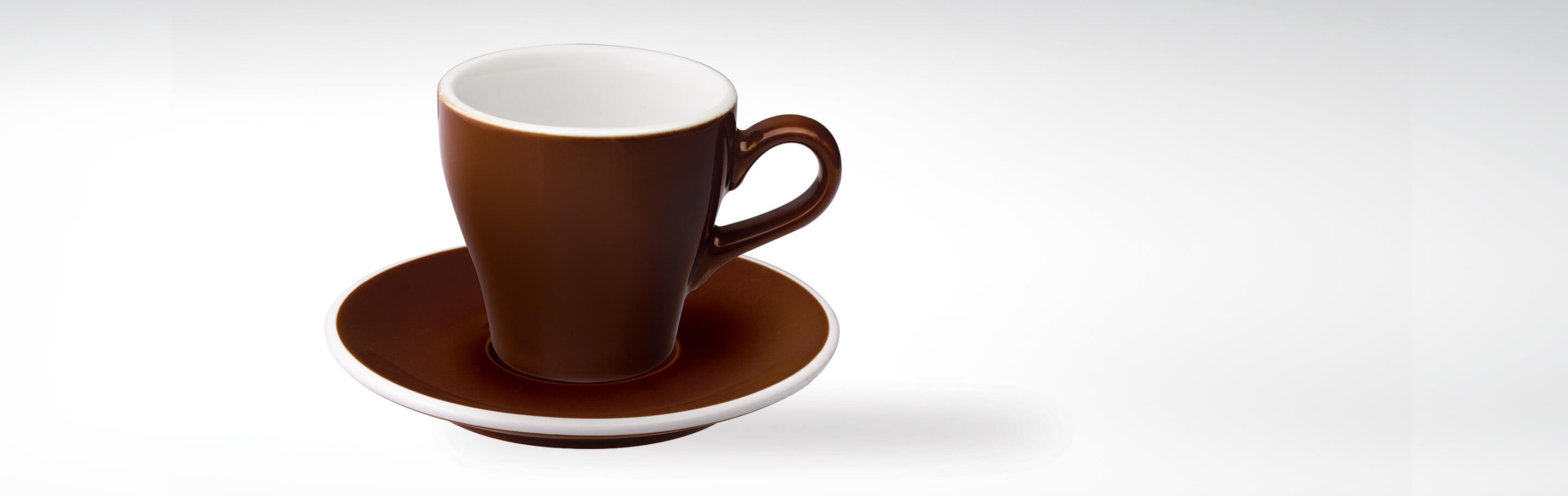 Braune Tasse mit passender Untertasse auf weißem Hintergrund