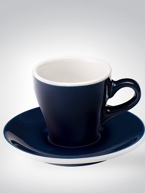 Dunkelblaue Espressotasse mit passender Untertasse, in Weiß und Blau gehalten, vor neutralem Hintergrund