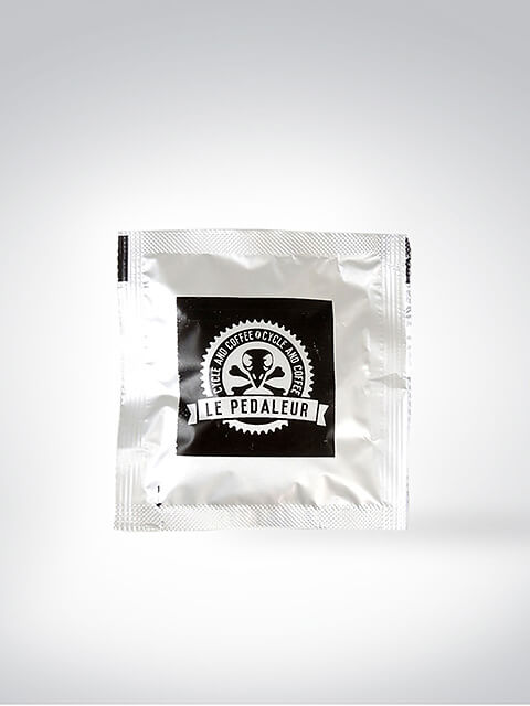 Einzelportion Kaffeepulver von Le Pedaleur mit schwarzem Logo auf weißer Verpackung