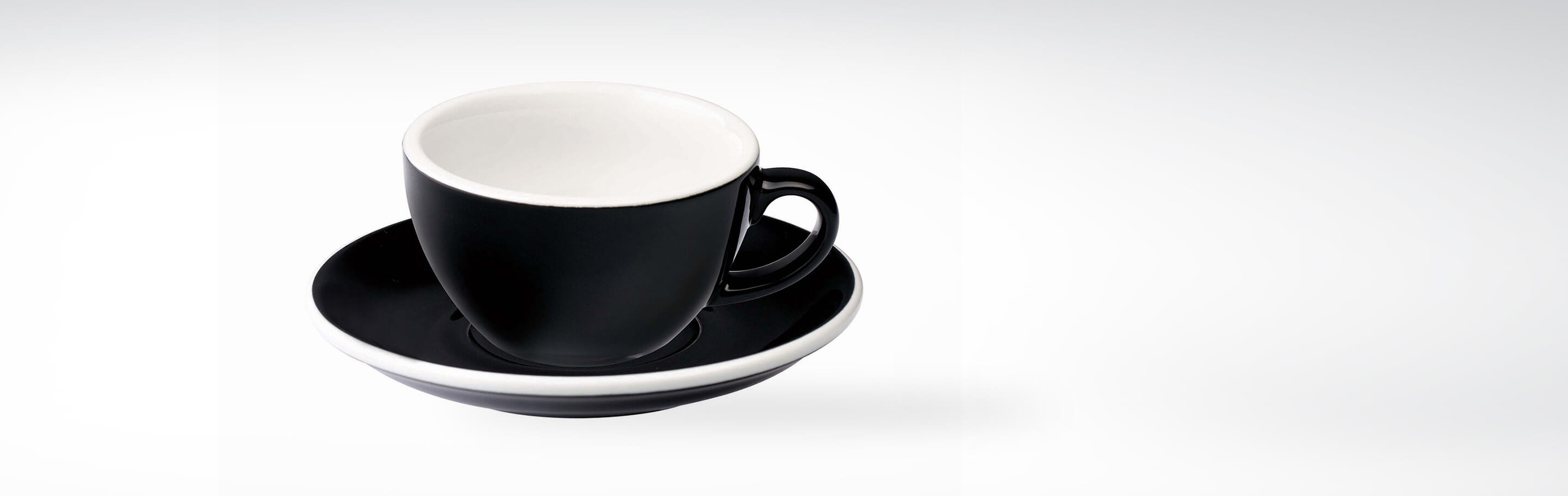 Eine stilvolle schwarze Kaffeetasse mit passender Untertasse auf weißem Hintergrund