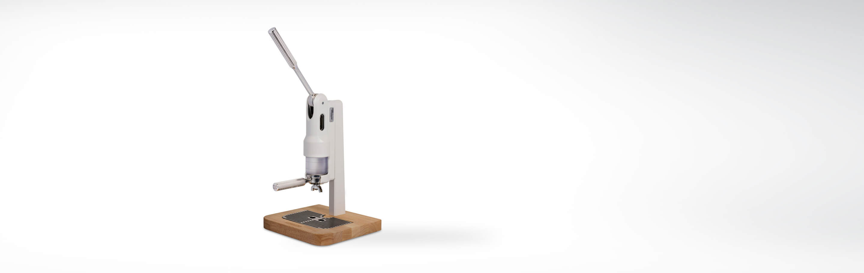 Manuelle Kaffeemühle mit Holzsockel und Hebel auf weißem Hintergrund