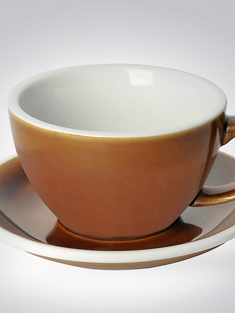 Braune Kaffeetasse aus Keramik mit passender Untertasse auf grauem Hintergrund