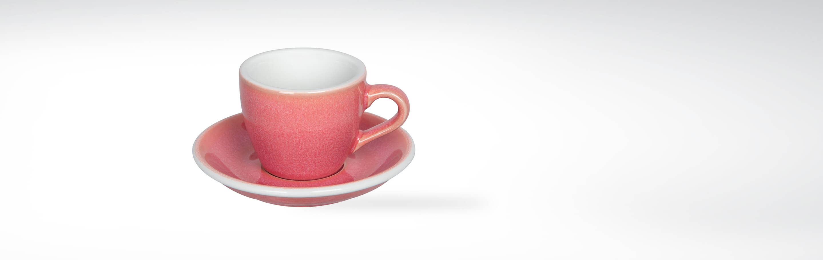 Rosa Espressotasse mit passendem Unterteller, aus hochwertiger Keramik gefertigt, auf weißem Hintergrund