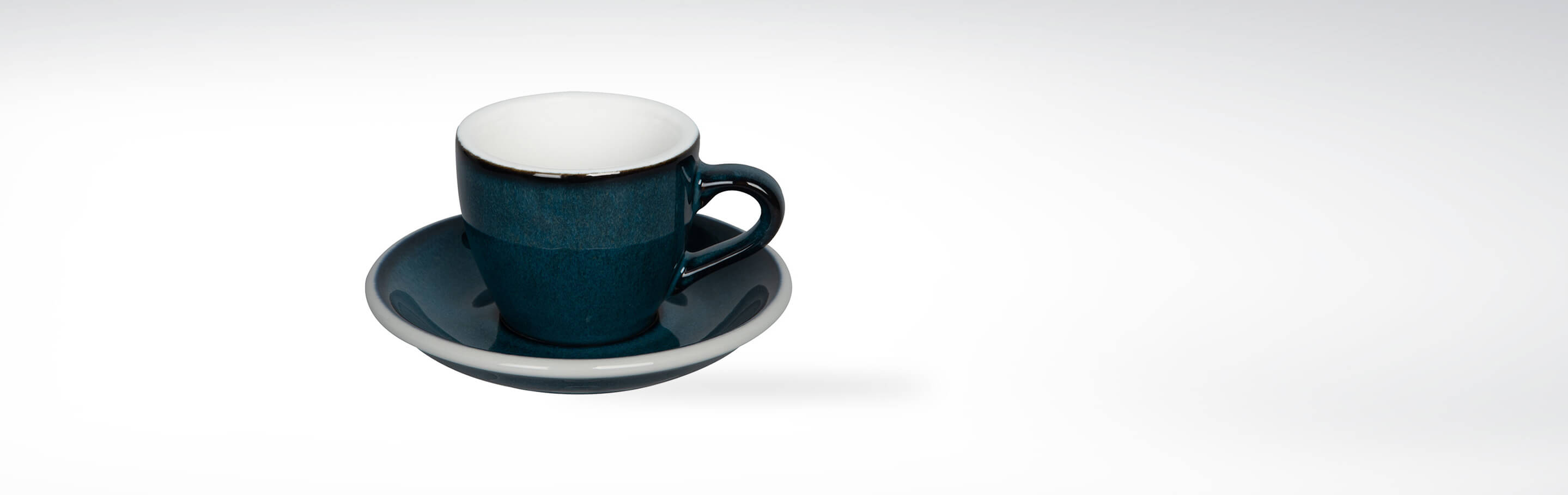Blaue Espressotasse mit Untertasse auf weißem Hintergrund