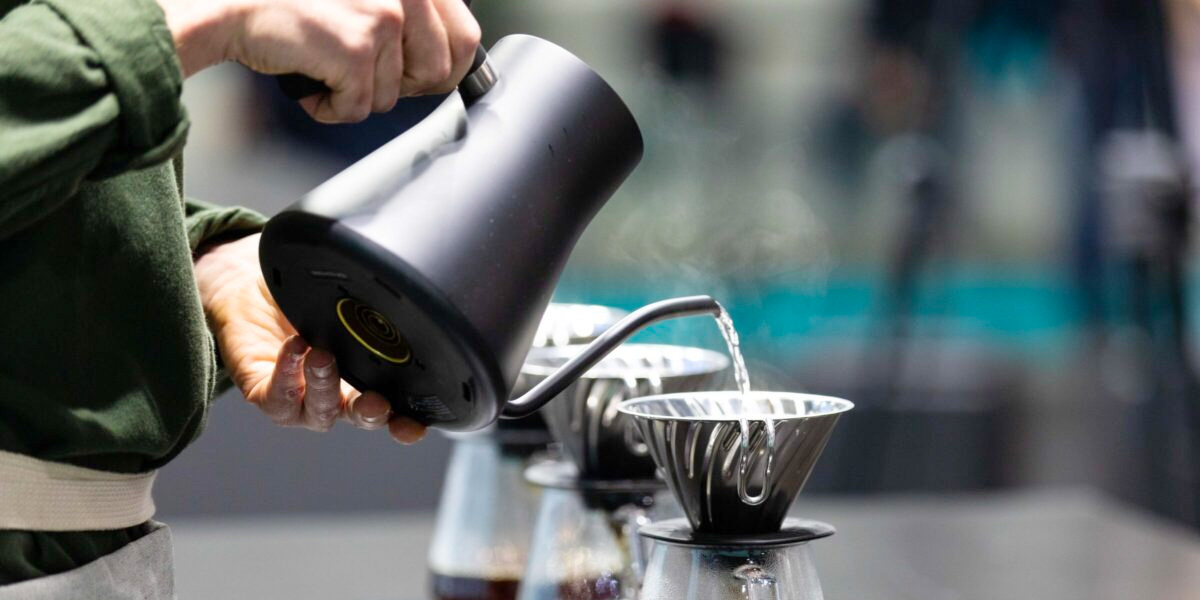 Nahaufnahme eines Wasserkochers, aus dem Wasser in einen Kaffeefilter gegossen wird