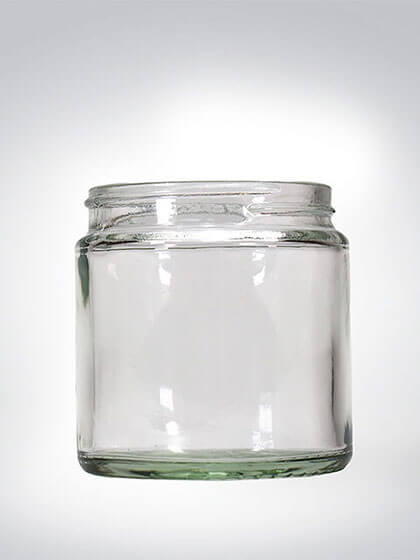 Leeres, klares Glasgefäß vor neutralem Hintergrund