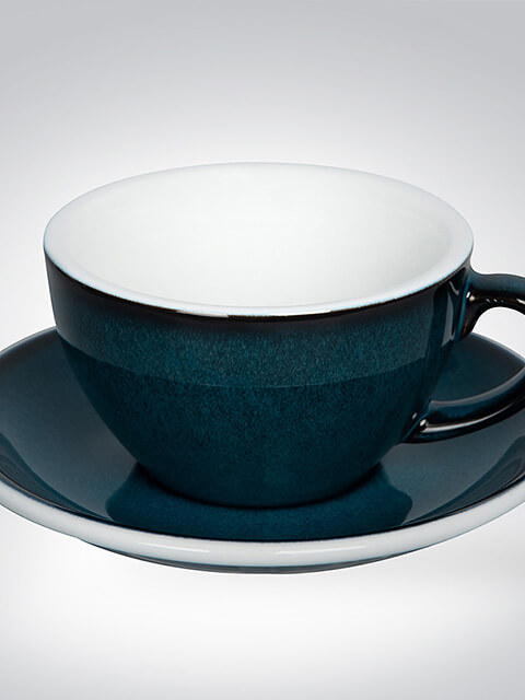 Dunkelblaue Teetasse mit passendem Unterteller auf weißem Hintergrund