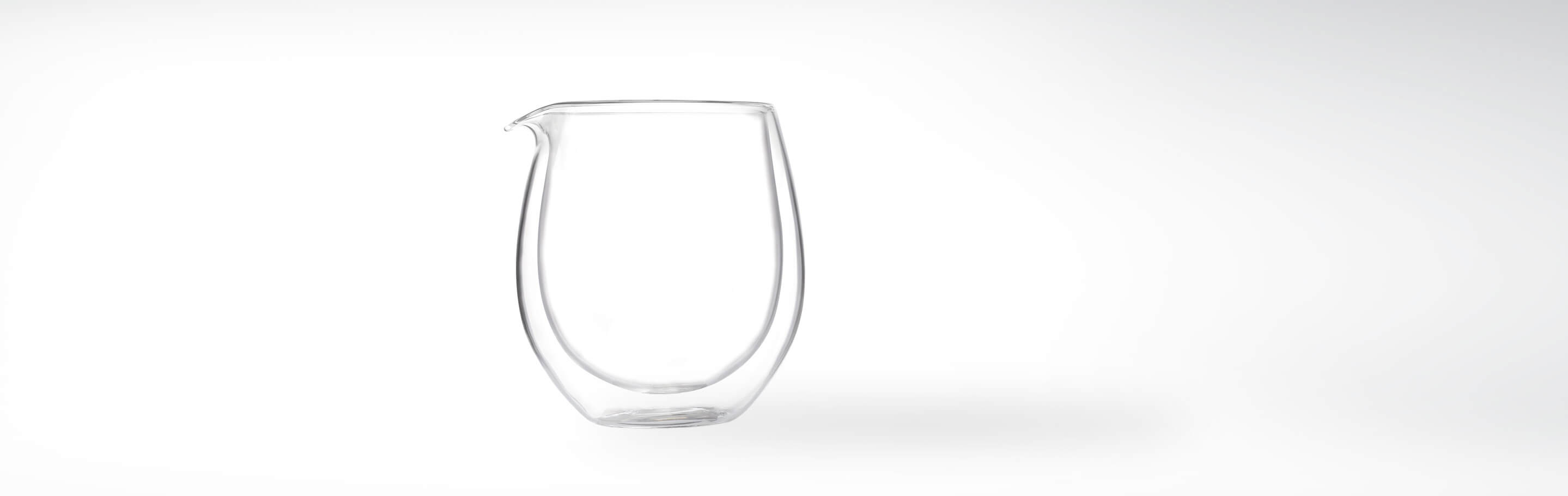 Doppelwandige Glaskaraffe mit Ausguss auf weißem Hintergrund