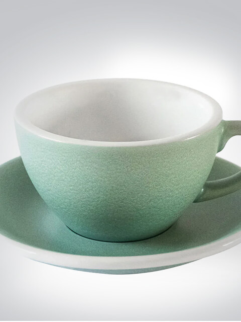 Nahaufnahme einer eleganten, hellgrünen Tasse mit passender Untertasse